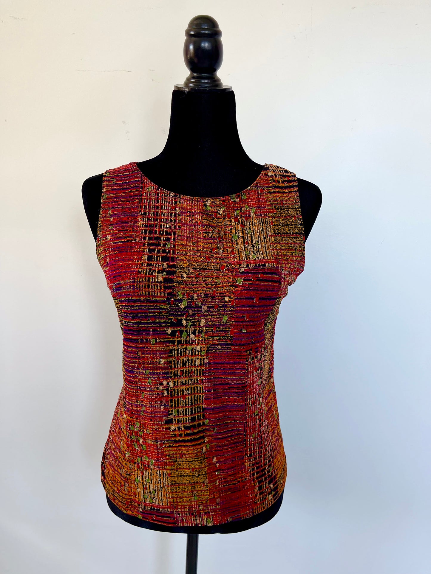 Multicolored sleeveless top on a mannequin against a white background
