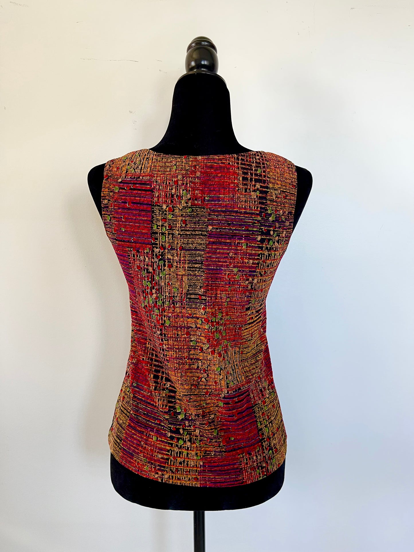 Multicolored patterned top on a mannequin against a white background